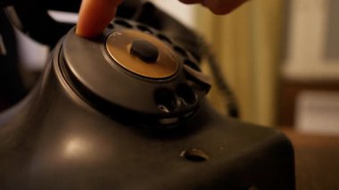 Yakın plan bir telefon araması. Birini aramak için numara çeviriyorum. Geçmişten kalma bir telefon. Eski bir ofis ortamında modası geçmiş teknoloji.
