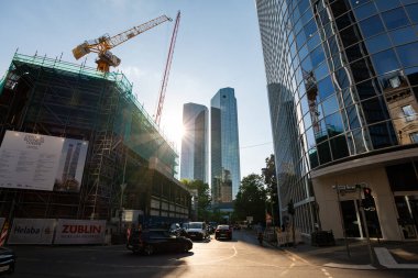 FRANKFURT, Almanya - 13. Mayıs 2025: Deutsche Bank sokağın sonundaki ikiz kuleler. Şehir merkezinin sokak manzaralı gökdelen binaları. Merkez İş Kulesi bir inşaat alanıdır..
