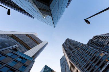 FRANKFURT, Almanya - 13. Mayıs 2025: FFM 'nin bankacılık bölgesinde gökdelenler. Gökyüzünde yukarıdaki ofis mimarisine bakıyorduk. Kurbağa bakış açısından modern kuleler.