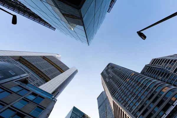 FRANKFURT, Almanya - 13. Mayıs 2025: FFM 'nin bankacılık bölgesinde gökdelenler. Gökyüzünde yukarıdaki ofis mimarisine bakıyorduk. Kurbağa bakış açısından modern kuleler.
