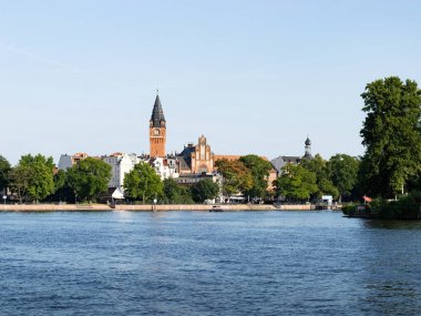 BERLİN, ALMANY - 11. Temmuz 2023: Spree nehrinden Koepenick 'teki belediye binası. Saatli uzun kule çatıların üzerindedir. Seyahat yeri olarak devlet binası.