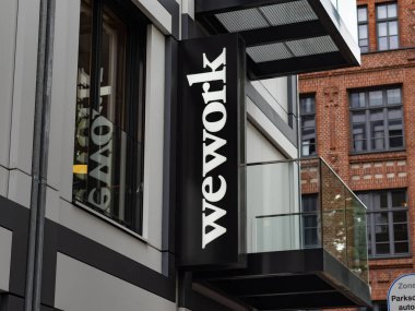 BERLİN, Almanya - 13. Temmuz 2023: Dışarıdaki bir ofis binasının logosu üzerinde çalışıyoruz. Ortak çalışma ve ortak alan teklif şirketinin reklamı. Hisse ekonomisi modern bir iş modelidir..