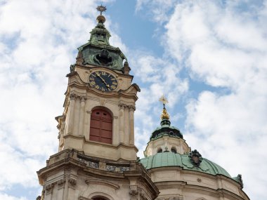 PRAG, CZECHIA - 1. Ekim 2024: St. Nicholas Kilisesi çan kulesi dış bina. Küçük Şehir 'de (Mala Strana) Barok tarzında mimarlık. Büyük saate yakın çekim..