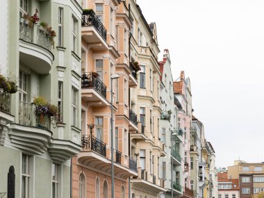Prag, Çek Cumhuriyeti 'nde renkli eski bina cepheleri. Yeni sanat mimarisi tarzında pastel renkte dış görünüş. Yerleşim bölgesinde çiçekli güzel balkonlar..