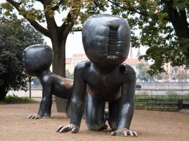 PRAG, CZECHIA - 2. Ekim 2024: Kentteki Bebekler (Miminka) Sanatçı David Cerny heykelleri. Kampa Müzesi 'nin yanındaki barkodlu sürünen bronz heykel..