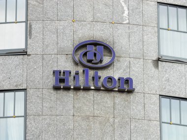 PRAG, CZECHIA - 3. Ekim 2024: Hilton logo tabelası otel duvarında. Amerikan çokuluslu konukseverlik şirketi Avrupa 'da hizmet sunuyor. Praha 'da seyahat ve turizm sektörü.