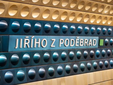 Prag, Çek Cumhuriyeti 'ndeki Jiriho z Podebrad metro istasyonu. Metro tünelinde konum isminin işareti. Sarı ve mavi alüminyum şekiller duvara monte edilmiştir. Büyük şehirde toplu taşıma.