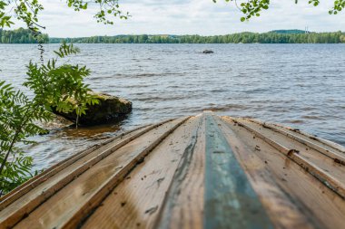 Tampere Finlandiya plajında tahta tekne baş aşağı duruyor.