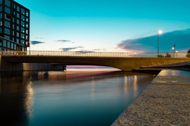 Tampere Finlandiya 'daki köprünün altından yansıyan günbatımı renkleri
