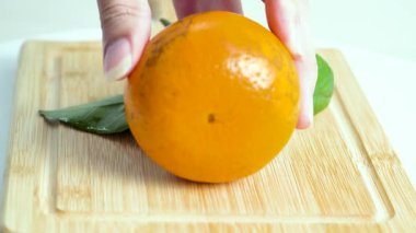 Bambu kesme tahtasında yarım portakal taze ve sulu.