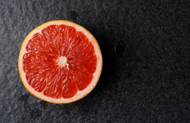 Siyah arka planda dilimlenmiş greyfurt.