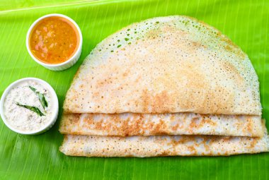 Muz yaprağında sambar ve baharatla servis edilir.