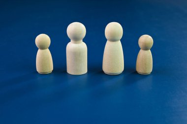 Mavi arka planda dört tahta heykel.