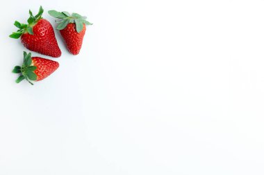 Temiz beyaz arka planda sol üstte üç taze çilek var. Yiyecek markalaşması, organik ürün promosyonları ve sağlıklı beslenme görselleri için ideal bir minimalist kompozisyon..