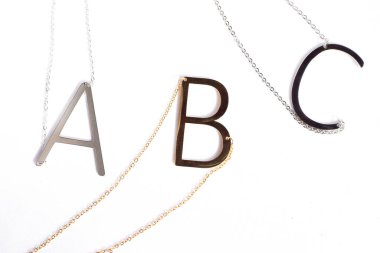 Altın ve gümüşten yapılmış büyük harf gerdanlıkları. Modern moda aksesuarı, kişisel mücevherler, minimalist betimlemeler ve şık monogram hediyeler için mükemmel..