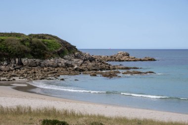Praia de Lourido 'daki Atlantik kıyıları, Muxa, Galiçya, İspanya. Yumuşak kumullar, sakin deniz ve kıyıya giden yeşil bir patika içeren panoramik sahil manzarası.