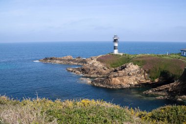 Kuzey İspanya 'nın Galiçya kıyı bölgesinde Ribadeo yakınlarında engebeli uçurumlar ve Atlantik sularıyla çevrili Pancha Adası deniz feneri..