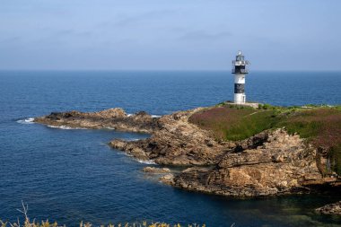 Kuzey İspanya 'nın Galiçya kıyı bölgesinde Ribadeo yakınlarında engebeli uçurumlar ve Atlantik sularıyla çevrili Pancha Adası deniz feneri..