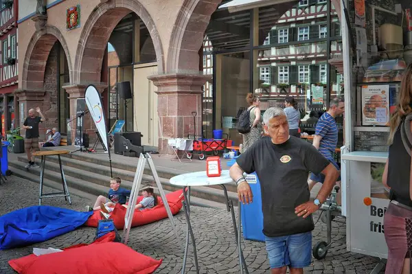 Sakinleş. Almanya. 31 Mayıs 2025 şehir tatili. Görüntü, canlı bir kasaba meydanını, tarihi yarı ahşap binalar, açık hava koltukları ve atmosferin keyfini çıkaran insanlarla yakalıyor..