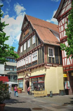 Sakinleş. Almanya. 31 Mayıs 2025 şehir tatili. Görüntü, canlı bir kasaba meydanını, tarihi yarı ahşap binalar, açık hava koltukları ve atmosferin keyfini çıkaran insanlarla yakalıyor..