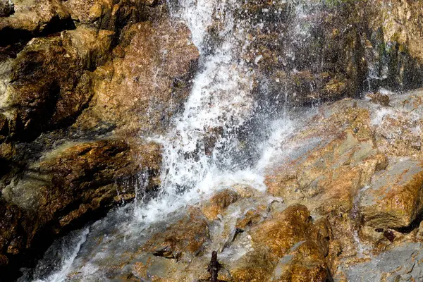 Küçük, pitoresk bir şelale Eliasquelle Kufstein, Tyrol, Avusturya 'da yosun kaplı kayalardan aşağı yuvarlanıyor ve akarsu tarafından kısmen gizleniyor..