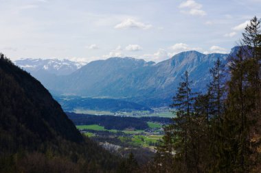 Walleralm 'dan nefes kesici manzara görkemli dağları gösteriyor yemyeşil bir vadiyi çevreleyen ormanlar ve küçük köyler parçalı bulutlu bir gökyüzünün altında.