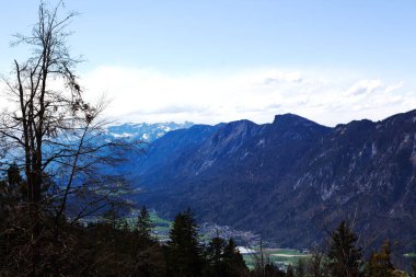 Nefes kesen bir panoramik manzara, bulutsuz bir gökyüzünün altında yükselen dağlar ve yemyeşil ormanlarla çevrili bir vadide yuva yapmış büyüleyici bir kasabayı gözler önüne seriyor.