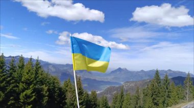 Rüzgarda gururla dalgalanan Ukrayna bayrağı heybetli dağların ve parlak mavi gökyüzünün önünde dimdik duruyordu.