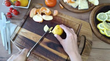 Kırsal bir mutfakta eller ustalıkla taze limon kesiyor. Canlı renkler ve besleyici güzelliklerle enfes bir ziyafet bizi bekliyor..