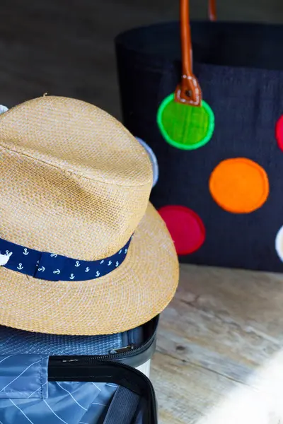 Heyecan verici bir geziye hazırlanmak için bavul hazırlamak, içinde bir denizci bandosu ve canlı, desenli bir çanta olan büyüleyici bir hasır şapka. Heyecan havayı dolduruyor..