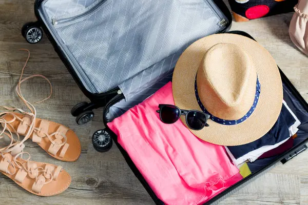 Giysileri ve aksesuarları şık bir bavula yerleştirerek güneşli bir maceraya hazırlanmak, ilerideki yolculuk için heyecan uyandırıyor..