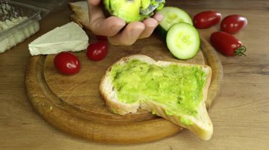 Lezzetli bir avokado yaratma sanatına dalın lezzetli domatesler ve taze bir ısırık için gevrek salatalık dilimleriyle zenginleştirilmiş sağlıklı ekmekler üzerine..