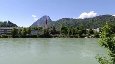 Huzurlu bir nehir Hanı Avusturya 'nın Kufstein kentinin içinden akar, yemyeşil dağlarla çevrelenmiş ve açık mavi gökyüzünün altında yüksek kulesi olan tuhaf bir kilise bulunur..