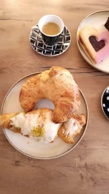 Ayçöreği ve tatlı ikramı da içeren taze hamur işlerinin tadını çıkarın. Huzurlu bir sabahta büyüleyici bir kafede zengin kahveyle mükemmel bir şekilde eşleştirilmiş..