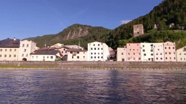 Güneşli bir günde dağlarla çevrili bu büyüleyici köydeki çarpıcı mimari ve sakin suları keşfedin. Doğanın ve tarihin güzelliğini gösterin..