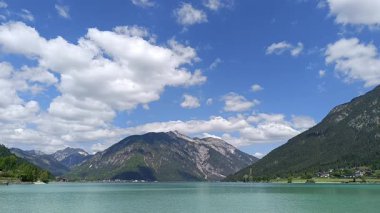 Avusturya, Tyrol 'daki Achensee' nin nefes kesici güzelliğini tecrübe edin. Berrak turkuaz sular, canlı bir gökyüzünün altındaki dağları yansıtarak mükemmel bir kaçış yolu yaratır..