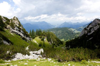 Tyrol 'un çarpıcı manzaralarını keşfeden Avusturya, kayalık dağ oluşumları tarafından çerçevelenmiş yeşil vadilerin muhteşem bir manzarasını gözler önüne seriyor. Sahne, bulutların ve ışığın canlı doğal çevredeki etkileşimini yakalar.