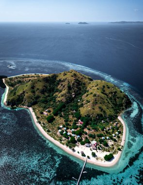 Flores Denizi 'ndeki tropik Kanawa Adası' nın havadan görünüşü, tatil köyleri ve bungalovları Komodo Ulusal Parkı, Doğu Nusa Tenggara, Endonezya 'daki beyaz kum ve turkuaz sulara bakıyor..