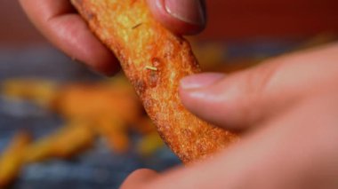 Arka planda patates kızartmasıyla elleri çıtır çıtır yuca yapıyor. Yüksek kalite 4k görüntü