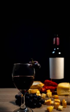 Şarap, peynir, üzüm, ekmek, koyu arkaplanlı zarif bir kompozisyon. Yüksek kalite fotoğraf