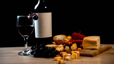 Şarap, peynir, üzüm, ekmek, koyu arkaplanlı zarif bir kompozisyon. Yüksek kalite fotoğraf