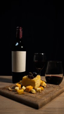 Şarap, peynir, üzüm, ekmek, koyu arkaplanlı zarif bir kompozisyon. Yüksek kalite fotoğraf