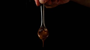 Siyah arka planda elle tutulan erimiş çikolatalı kaşık. Yüksek kalite fotoğraf