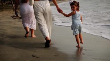  Lezbiyen çift gün batımında kızlarıyla sahilde yürüyor. Yüksek kalite 4k görüntü