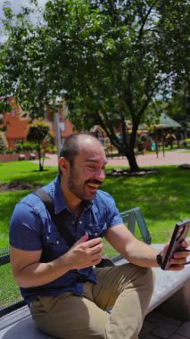 Güneşli bir günde parkta gülümseyen yakışıklı kel adam. Yüksek kalite 4k görüntü