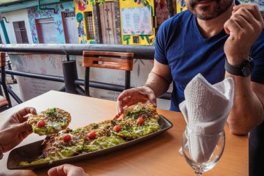  Latin gastronomi konsepti için tipik bir Kolombiya restoranında salsa ve guacamole yiyen iki Latin arkadaş. Yüksek kalite fotoğraf