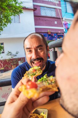  Latin gastronomi konsepti için tipik bir Kolombiya restoranında salsa ve guacamole yiyen iki Latin arkadaş. Yüksek kalite fotoğraf