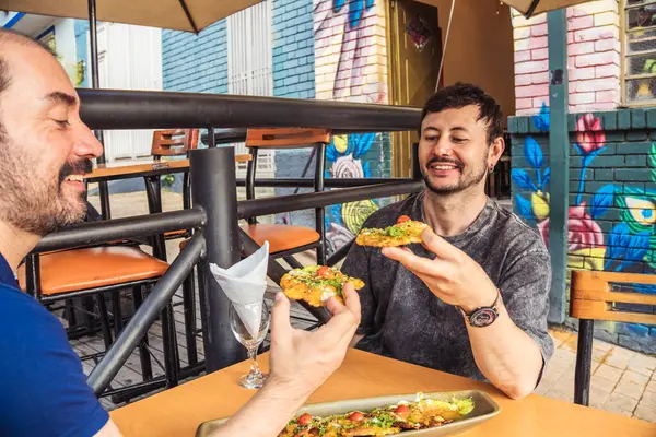  Latin gastronomi konsepti için tipik bir Kolombiya restoranında salsa ve guacamole yiyen iki Latin arkadaş. Yüksek kalite fotoğraf