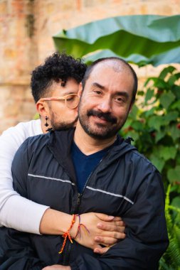 Olgun kel erkek çift ve genç kıvırcık saçlı eşcinsel inek gün batımında aşklarını gösteriyorlar aşk, çeşitlilik, gurur, özgürlük ve mutluluk kavramı için. Yüksek kalite fotoğraf