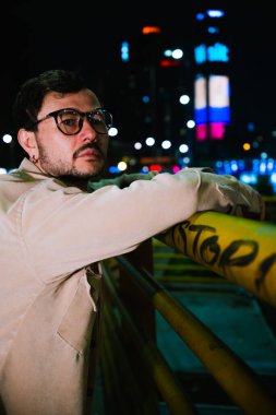 Tek başına genç bir adam gece hayatı konsepti için canlı renkli ışıkları olan Bogota şehrinin canlı gece hayatını izliyor. Yüksek kalite fotoğraf